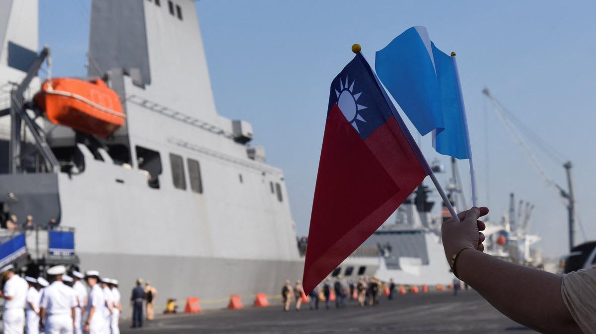 A person holds the Taiwan and Guatemala flags near the flagship warship PAN-SHI (AOE-532), one of three ships in Taiwan's Naval Friendship Squadron, arrives at Puerto Quetzal on a visit to Guatemala as part of its annual cadet training deployment, a goodwill mission aimed at strengthening ties while conducting naval exercises in Central America and the Caribbean, in Puerto Quetzal, San Jose, Escuintla, Guatemala, May 2, 2026. REUTERS/Cristina Chiquin