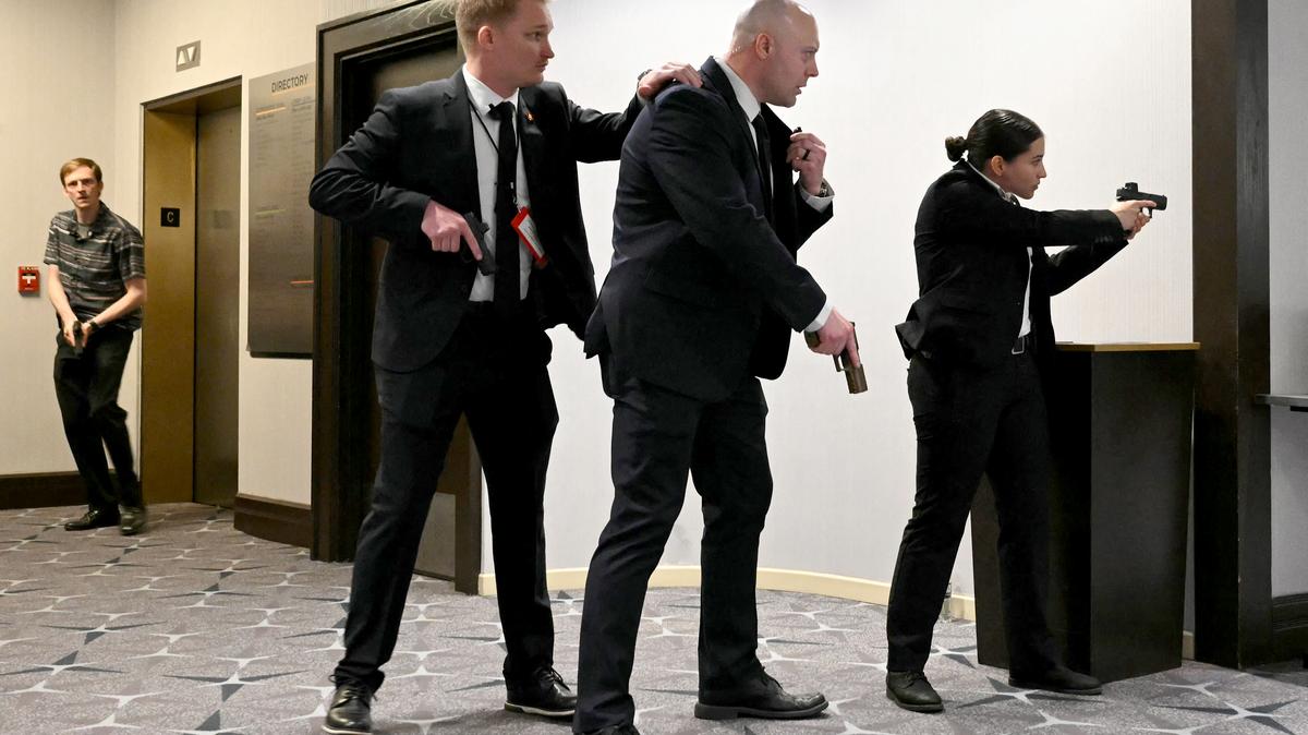 Agents draw their guns after loud bangs were heard during the White House Correspondents' dinner at the Washington Hilton in Washington, D.C., on April 25, 2026. President Trump attended the annual gala of the political press for the first time while in office. (Mandel Ngan/AFP/Getty Images/TNS)