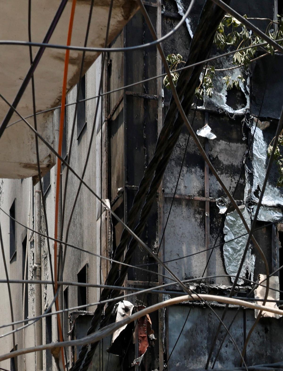 Firefighters and police officers stand at the site after a fire at a hotel in New Delhi, India, June 3, 2026. REUTERS/Adnan Abidi