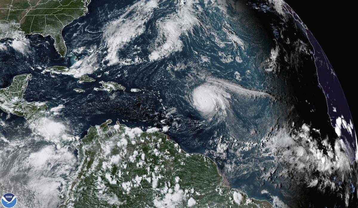 Esta imagen satelital proporcionada por la Administración Nacional Oceánica y Atmosférica (NOAA) muestra el huracán Sam, justo a la derecha del centro, en el océano Atlántico, el lunes 27 de septiembre de 2021,