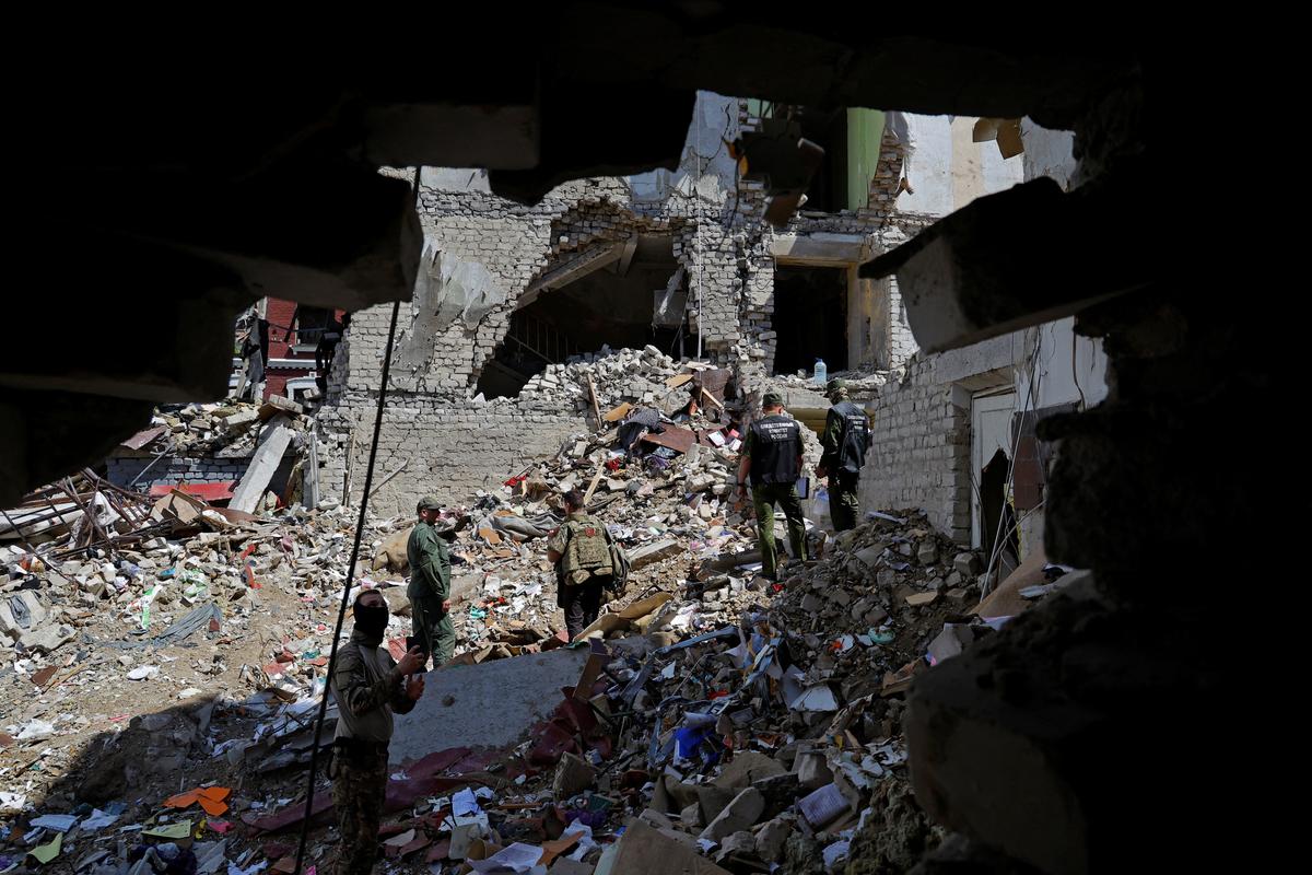Investigators work amid debris of a destroyed dormitory building of the Starobilsk College of Luhansk Pedagogical University following a recent attack, which Russian authorities called a Ukrainian drone strike, in the course of the Russia-Ukraine conflict in the town of Starobilsk (Starobelsk) in the Luhansk region, a Russian-controlled area of Ukraine, May 24, 2026. Reuters reported from Starobilsk on a media facility trip organised by the Ministry of Foreign Affairs of the Russian Federation on May 24, 2026. REUTERS/Alexander Ermochenko