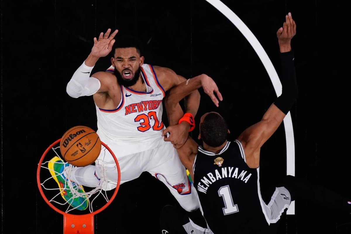  New York Knicks center Karl-Anthony Towns shoots the ball over San Antonio Spurs forward Victor Wembanyama during Game 1 of the 2026 NBA Finals at Frost Bank Center.