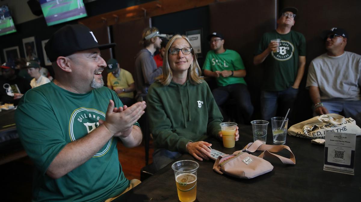 Oakland Ballers fans A.J. Tiras, left, and Emily Friedman cheer for the team during a watch party the Oakland Athletic Club in Oakland on May 21, 2024. (Jane Tyska/Bay Area News Group)