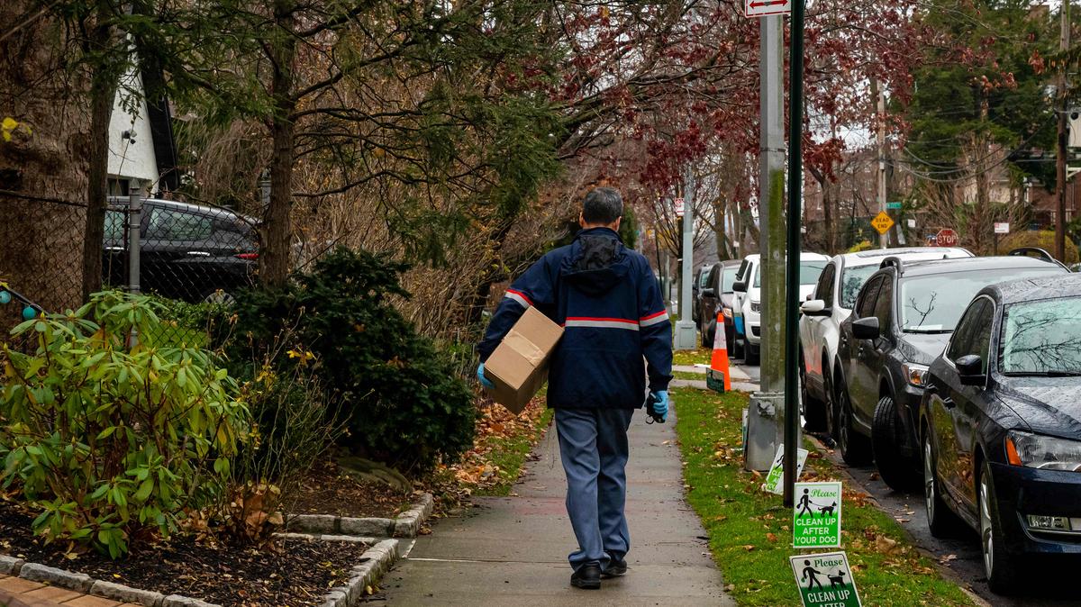 A United States Postal Service worker delivers a package to a home in New York, Dec. 18, 2021. The Postal Service has proposed a new rule that would allow people to mail handguns, after the Justice Department under the Trump administration claimed this year that a century-old ban on the practice was unconstitutional.