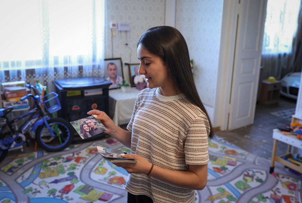 Anahit Grigoryan, who fled Nagorno-Karabakh, shows her family pictures in a house in the village of Oshakan, Armenia June 1, 2026. Hayk Baghdasaryan/Photolure via REUTERS