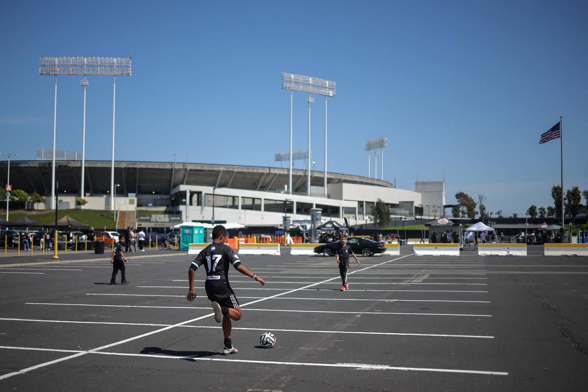 Kids play at the parking lot of the Oakland-Alameda County Coliseum stadium before a game between Oakland Roots SC and Sacramento Republic FC, in Oakland, California, U.S., May 16, 2026. REUTERS/Carlos Barria