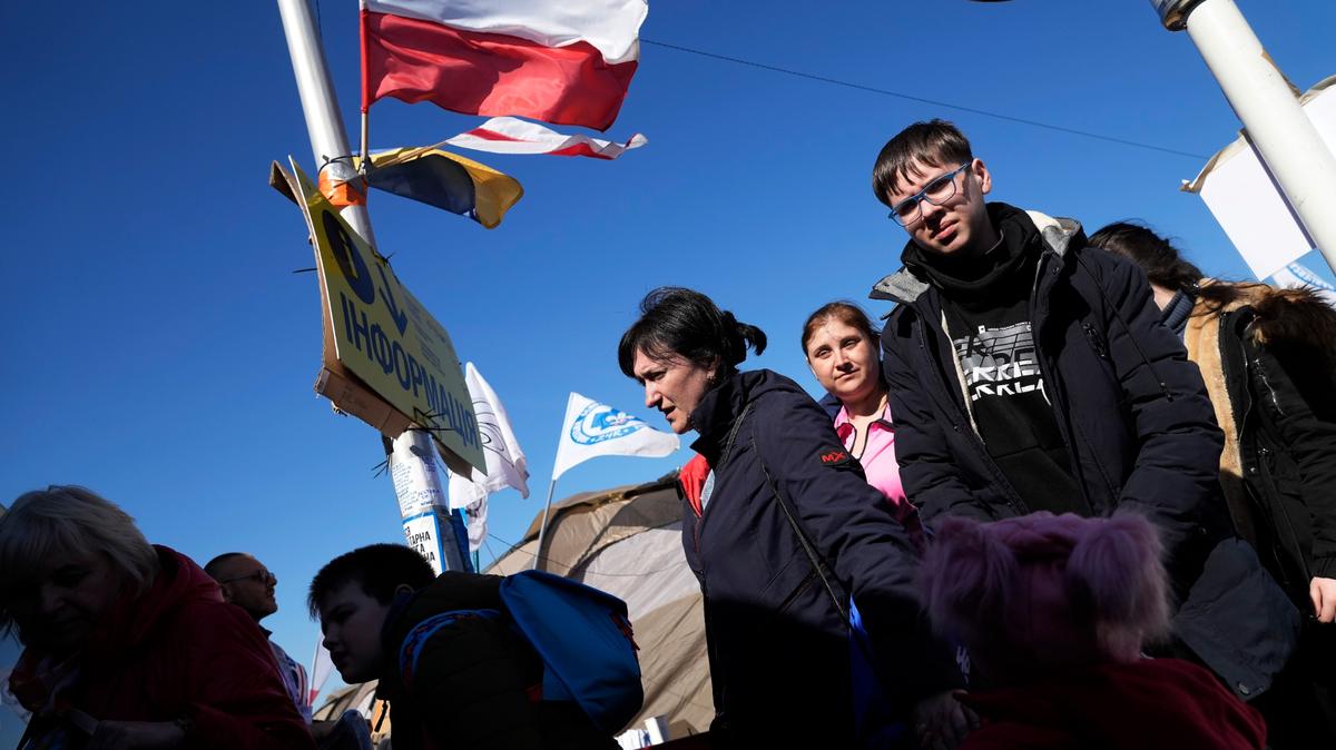 Refugiados ucranianos cruzan la frontera a Medyka, en el sureste de Polonia, el lunes 28 de marzo de 2022. (AP Foto/Sergei Grits)