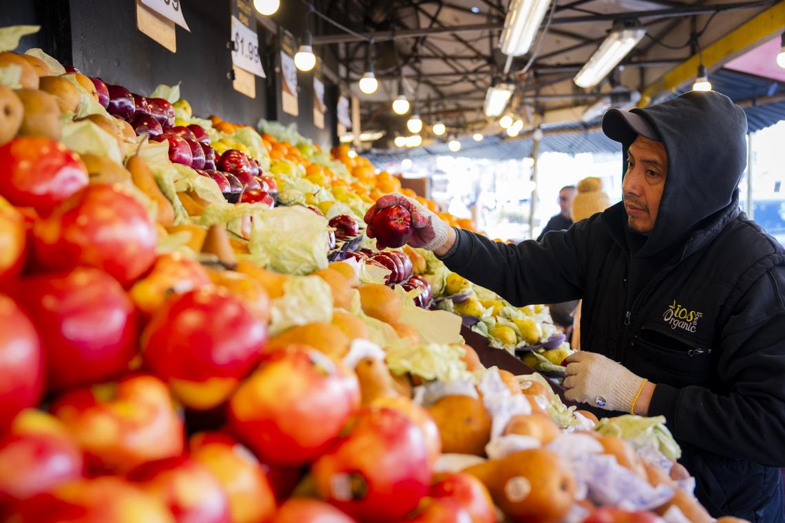 FILE -- A grocer at work in New York on March 19, 2026. Stocks may be soaring again, but the war in Iran has started to pinch the finances of many Americans, and gasoline averages around $4.10 per gallon nationally -- more than $1 per gallon higher than before the war began. (Vincent Alban/The New York Times)