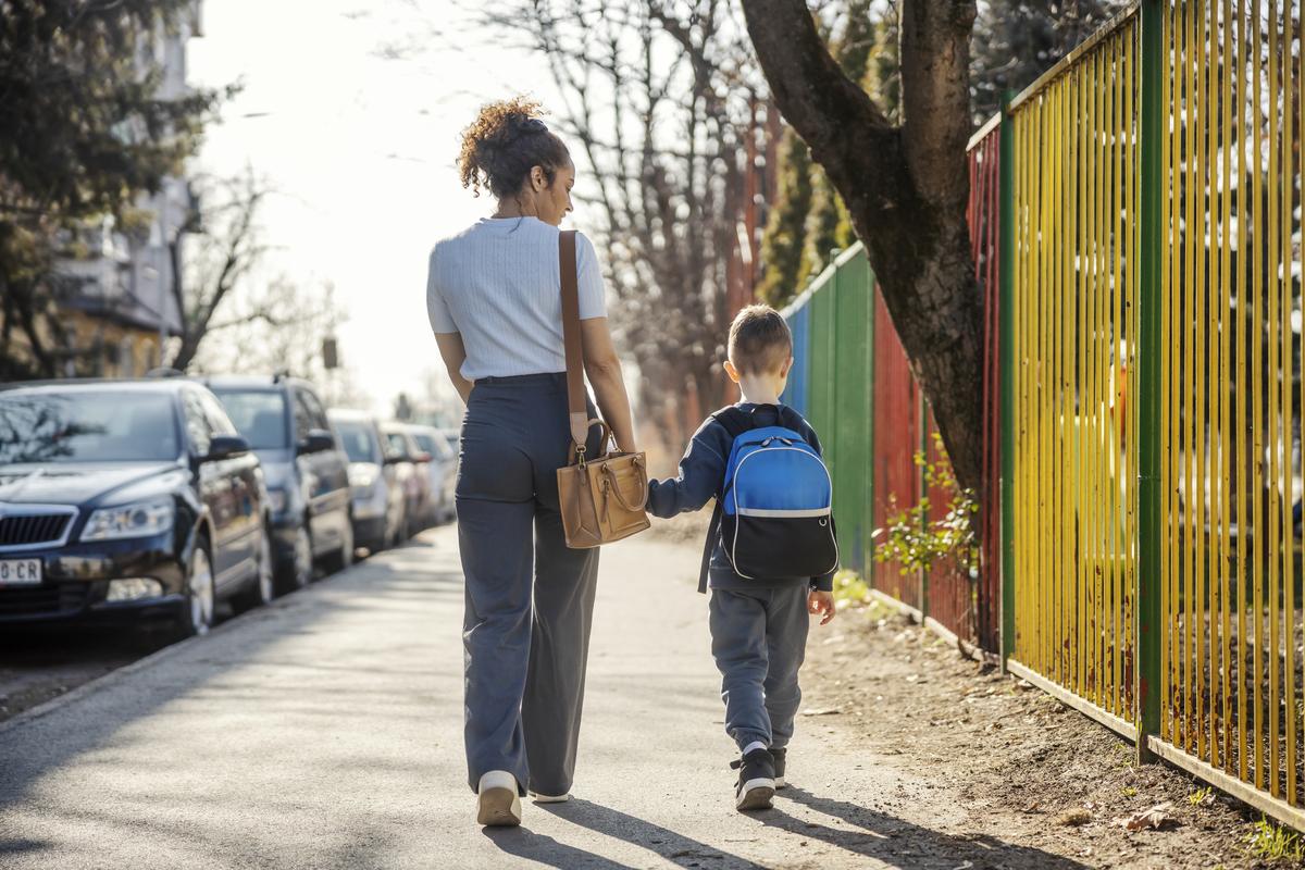  Back view of a young mother holding hands with her son and walking on a city street while going to the kindergarten. Credit: dusanpetkovic / iStock Getty 