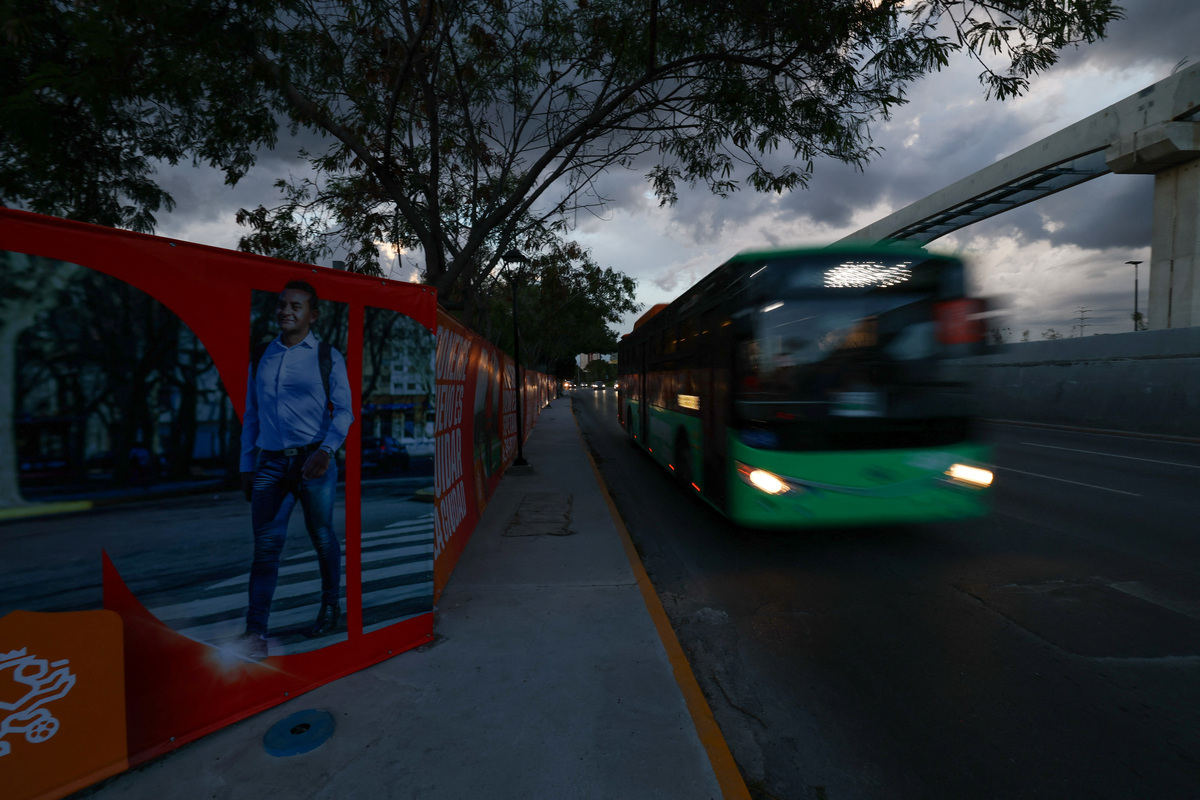 A bus drives by a fence bearing advertising from the Nuevo Leon state government, erected by authorities along a road to one of the stadiums for the 2026 FIFA World Cup and the airport to block poorer neighbourhoods from view, as many Mexicans say they feel excluded despite the tournament's return to the country, citing high ticket prices, paid television access and strict commercial restrictions, in Monterrey, Mexico, June 12, 2026. REUTERS/Daniel Becerril