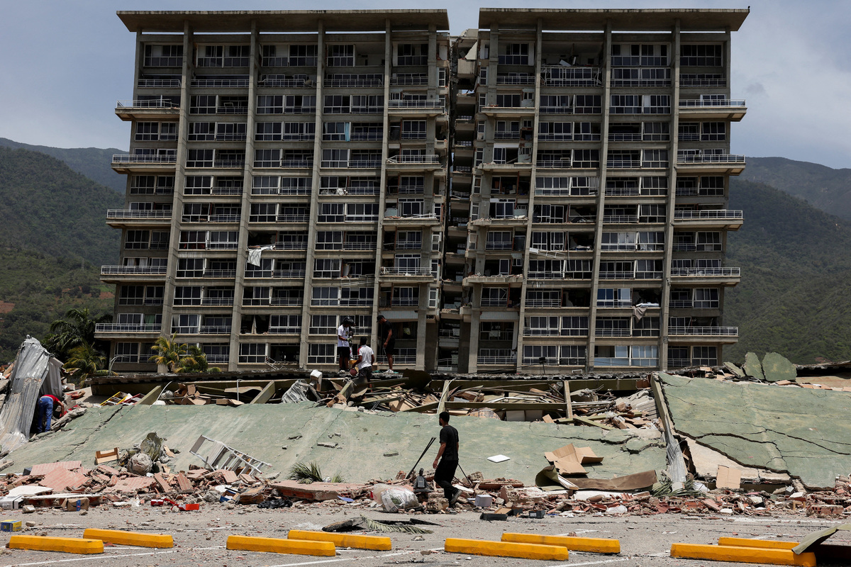 People inspect the rubble of a collapsed building after earthquakes hit the country, in La Guaira, Venezuela, June 25, 2026. REUTERS/Gaby Oraa