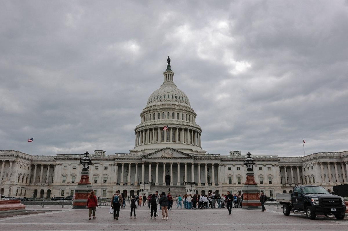 People stand near the U.S. Capitol building on a cloudy day in Washington, D.C., U.S., May 14, 2026. REUTERS/Kylie Cooper