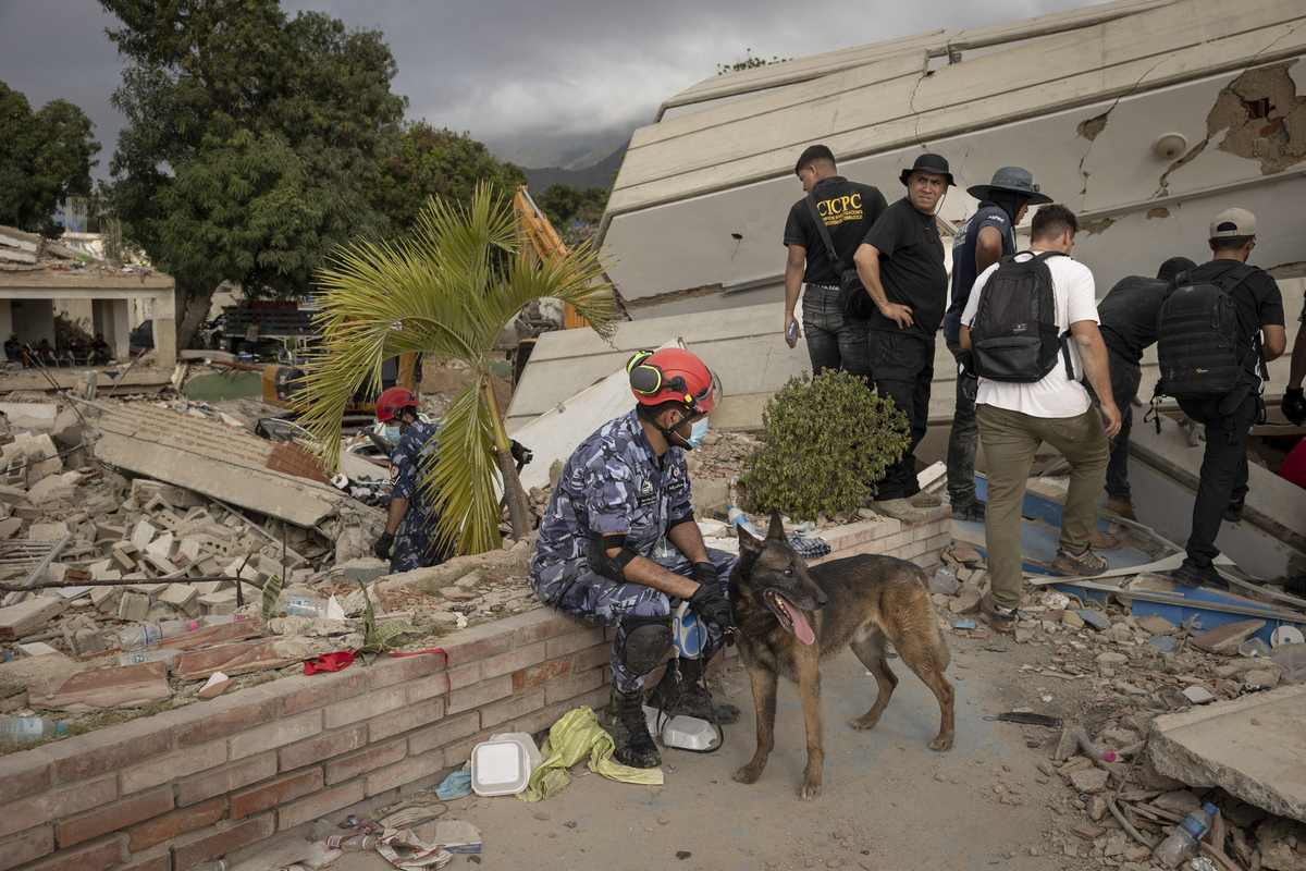 Rescue workers outside the Gabarra building that collapsed in last week's earthquakes in La Guaira, Venezuela, June 29, 2026. As the death toll mounts, thousands of bodies have overwhelmed Venezuela's forensic system, turning a seaport into a temporary morgue. (Fabiola Ferrero/The New York Times)