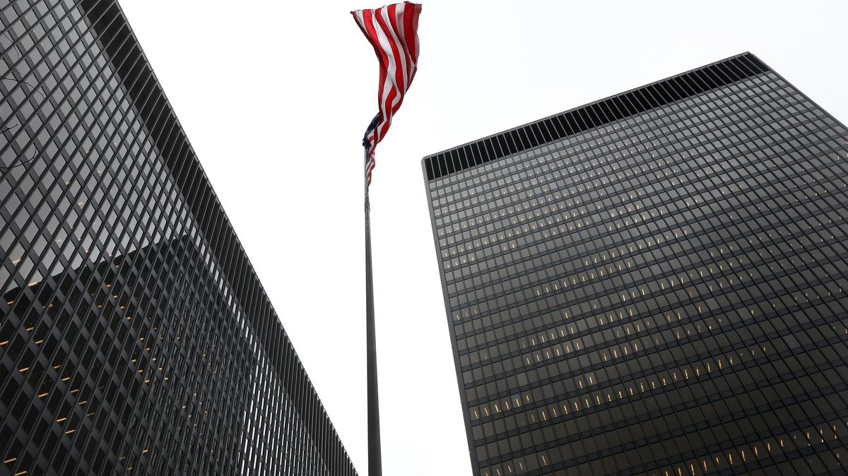 The Dirksen U.S. Courthouse at left and the Kluczynski Federal Building at right frame the American flag in downtown Chicago, Jan. 22, 2018. (Nancy Stone/Chicago Tribune/TNS)