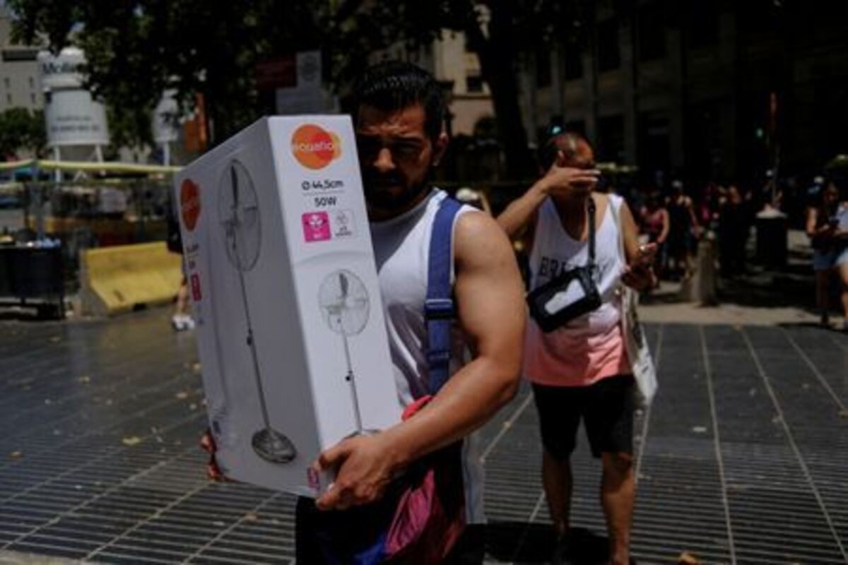 A man carries a newly purchased fan as temperatures rise, during a heatwave affecting a large part of Spain, in Barcelona, in Spain, June 21, 2026. REUTERS/Nacho Doce