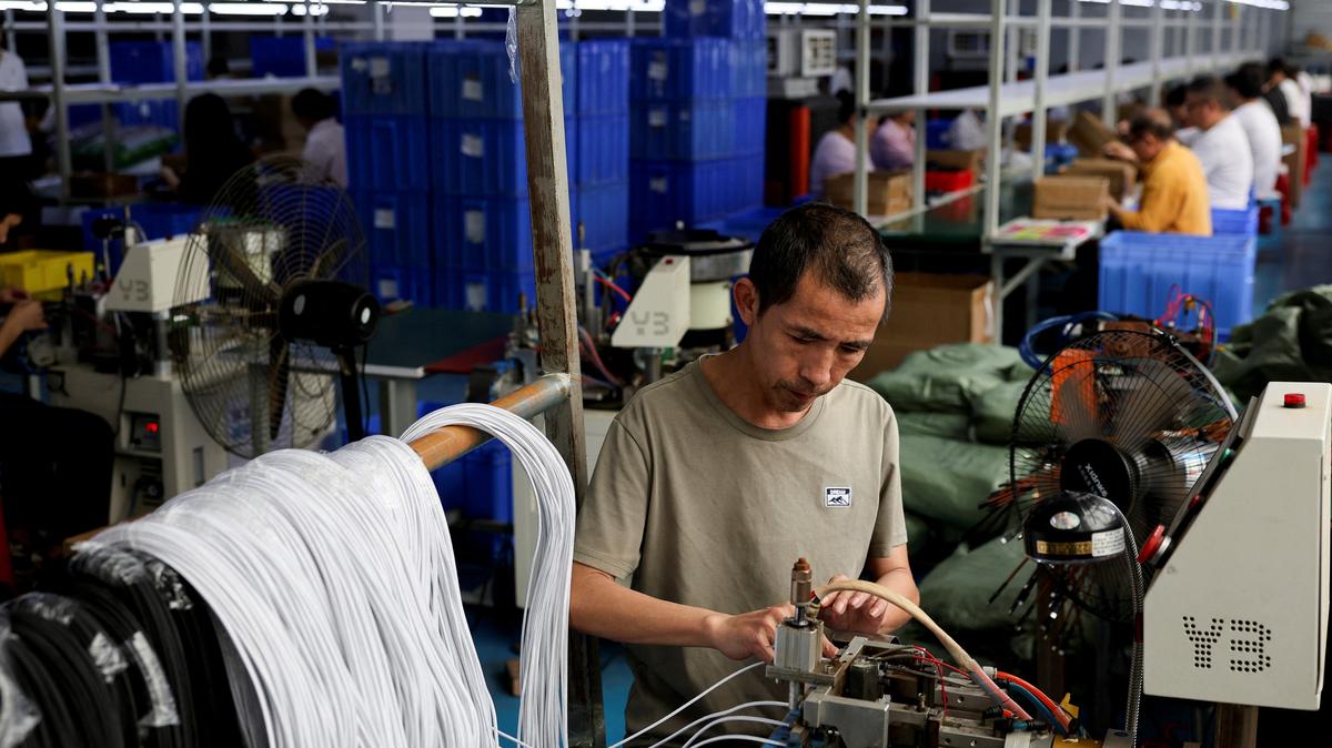 FILE PHOTO: An employee works on USB cables production at a plastic accessories factory in Dongguan, Guangdong province, China, April 2, 2026.  REUTERS/Go Nakamura/File Photo