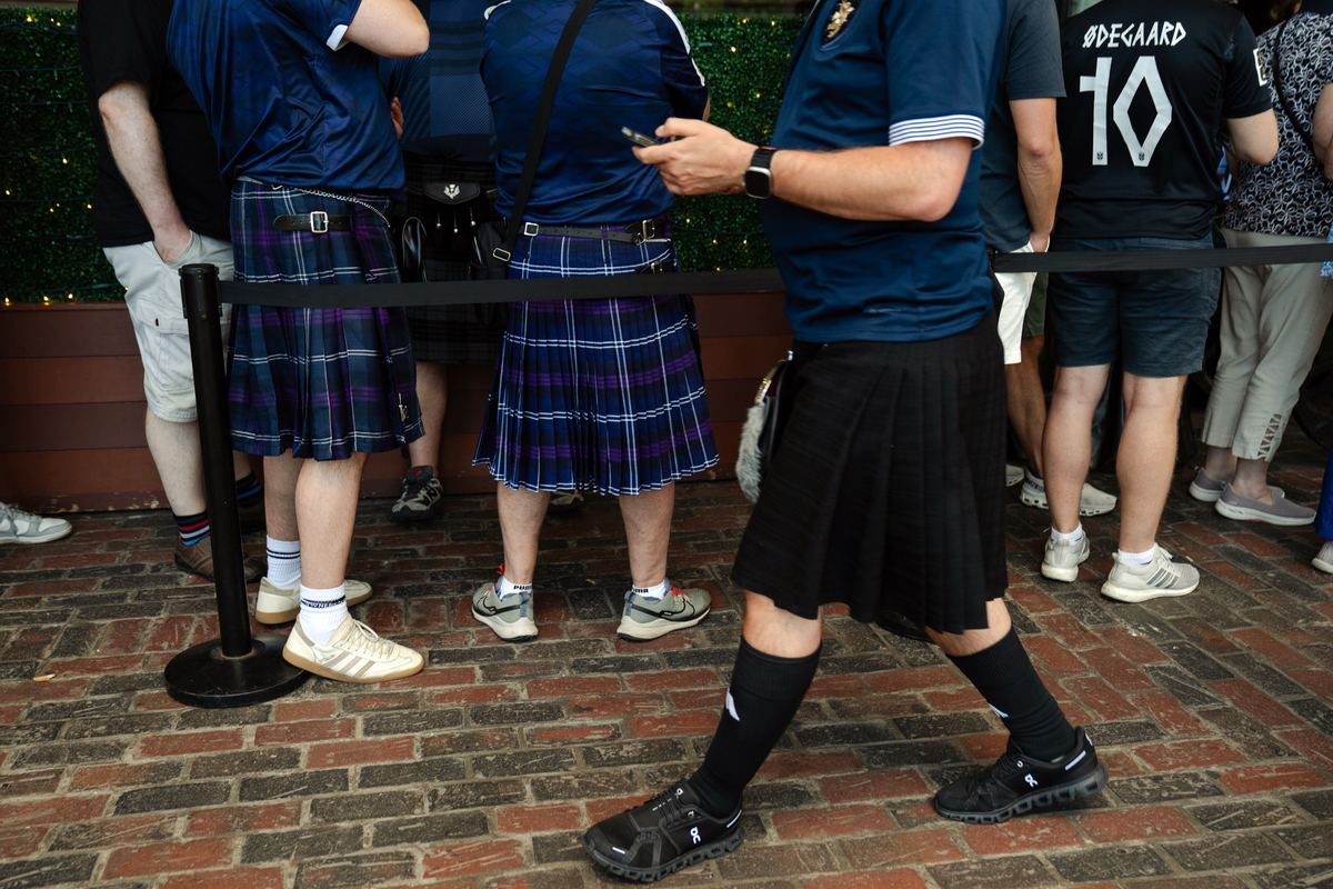 Scotland soccer fans, some wearing kilts, line up to enter The Dubliner Irish pub in Boston on June 17, 2026. The Tartan Army -- thousands of soccer fans from Scotland, here to see their national team play outside Boston in two matches of the World Cup -- are packing this old city's narrow streets, its subway cars, restaurants and pubs, and filling the air with the cry of bagpipes. (Sophie Park/The New York Times)