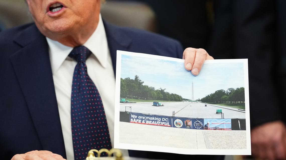 President Donald Trump holds a photo of the reflecting pool on the National Mall, emptied for cleaning, during an an Oval Office event at the White House in Washington on Thursday. Next up on President Trump's renovation tour of Washington, D.C.: the Lincoln Memorial reflecting pool, which he called "filthy" and "dirty" and in need of a major upgrade.