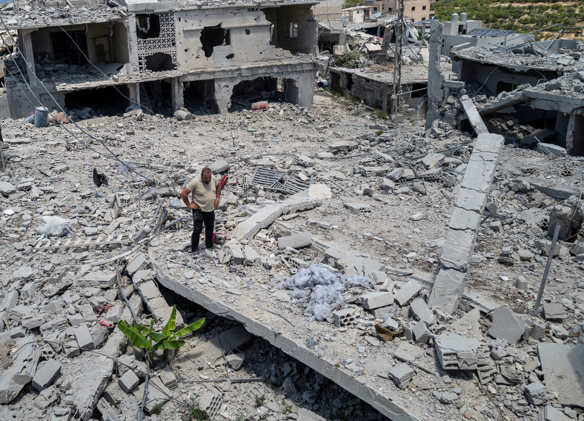 Abed Hachem, 46, stands as he looks to his house that was destroyed by an Israeli airstrike as he returns to his village after being displaced by the war, following the U.S.–Iran deal, in Qlailieh, Tyre district, Lebanon June 18, 2026. REUTERS/Zohra Bensemra