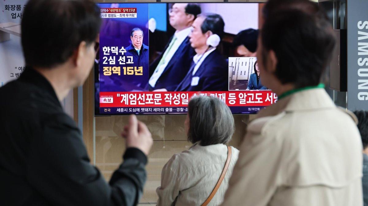 People watch a live TV broadcast at Seoul Station on Thursday showing the appeal hearing of former Prime Minister Han Duck-soo. The court reduced Han's sentence to 15 years over his role in former President Yoon Suk Yeol's brief imposition of martial law.. Photo by Yonhap