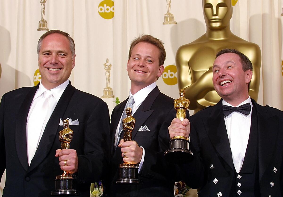  L-R Mike Minkler, Myron Nettinga and Chris Munro pose with their Oscars for best sound for the movie “Black Hawk Down” 24 March, 2002 at the 74th Academy Awards in Hollywood, CA. AFP PHOTO LEE CELANO (Photo by LEE CELANO / AFP) 