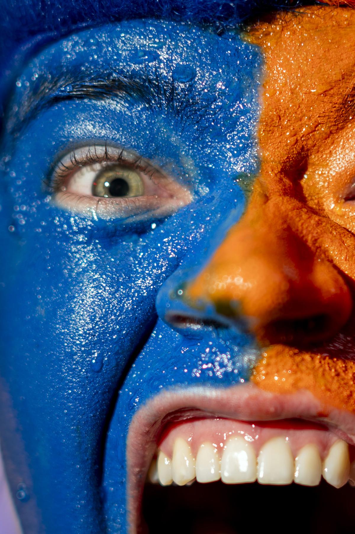 A Knicks fan, his face painted in the team colors, joins in the celebration outside Madison Square Garden in New York after his team swept the Cleveland Cavaliers in the Eastern Conference Finals to advance to the NBA Finals for the first time since 1999 on Monday night, May 25, 2026. Thousands of fans blocked traffic outside Madison Square Garden, even though the game was in Ohio and the outdoor watch parties at the Garden had been suspended because of rowdy fans. (Vincent Alban/The New York Times)