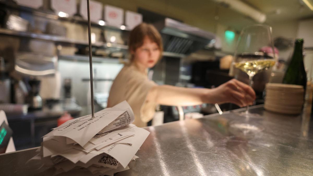 A waitress holds a glass of wine in the Skrepka restaurant in Moscow, Russia, April 17, 2026. REUTERS/Ramil Sitdikov