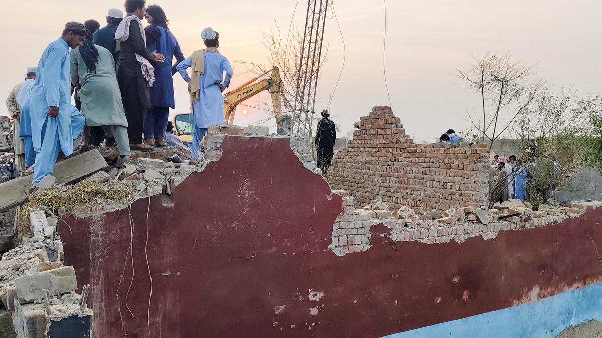 Residents gather on the rubble of a damaged police post after a car bombing in Bannu, Khyber Pakhtunkhwa province, Pakistan May 10, 2026. Picture taken with a mobile phone. REUTERS/Ehsan Khattak