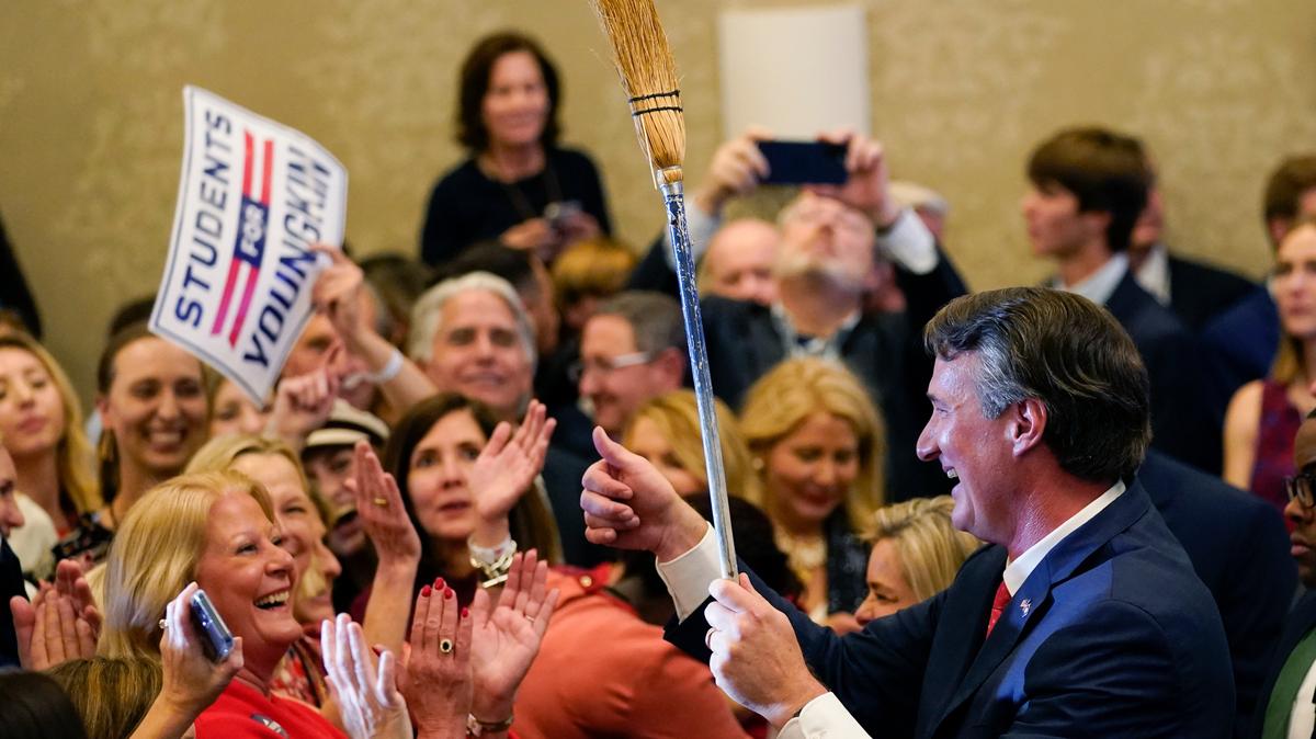 El gobernador electo de Virginia, el republicano Glenn Youngkin, sostiene una escoba mientras saluda a sus seguidores durante la celebración de su victoria en la madrugada del miércoles 3 de noviembre de 2021, en Chantilly, Virginia. Youngkin derroto a al demócrata Terry McAuliffe.  