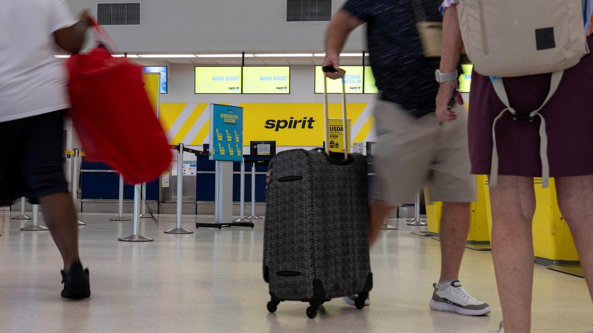 Passengers walk past the Spirit Airlines check-in area at Luis Munoz Marin International Airport after the airline announced it was ceasing operations early Saturday following an impasse in talks with some creditors over a $500 million government bailout plan, in Carolina, Puerto Rico, May 2, 2026. REUTERS/Ricardo Arduengo