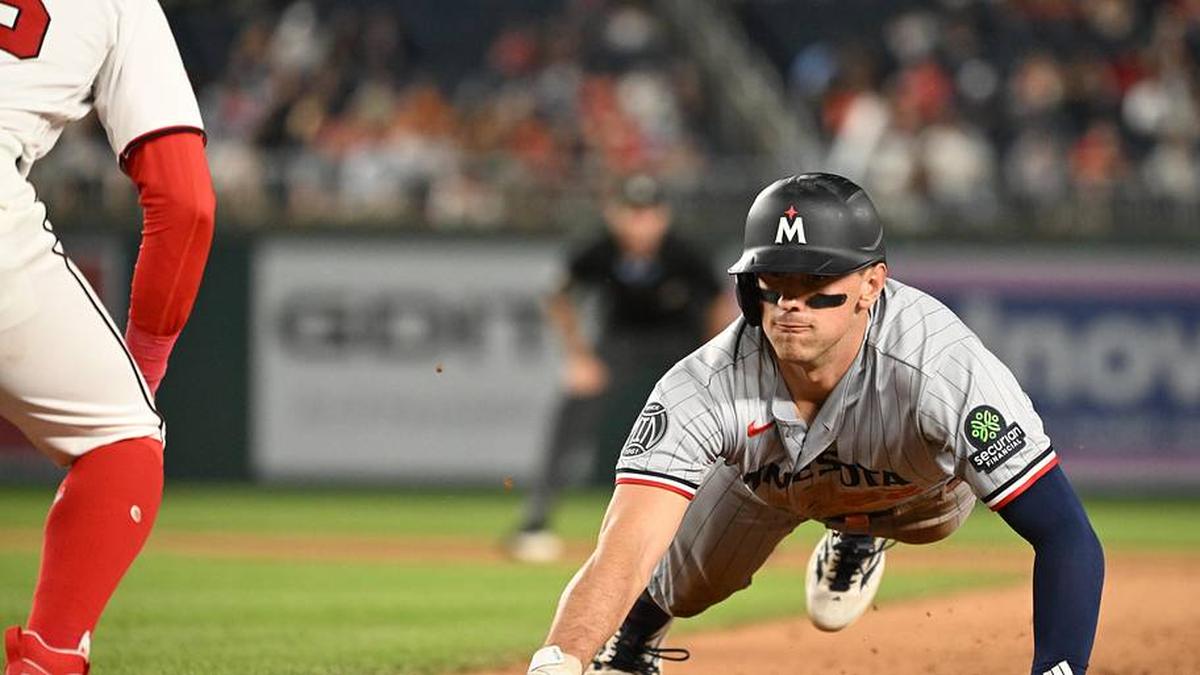  Minnesota Twins third baseman Brooks Lee (22) dives back to first base against the Washington Nationals during the eighth inning at Nationals Park. | Rafael Suanes-Imagn Images 