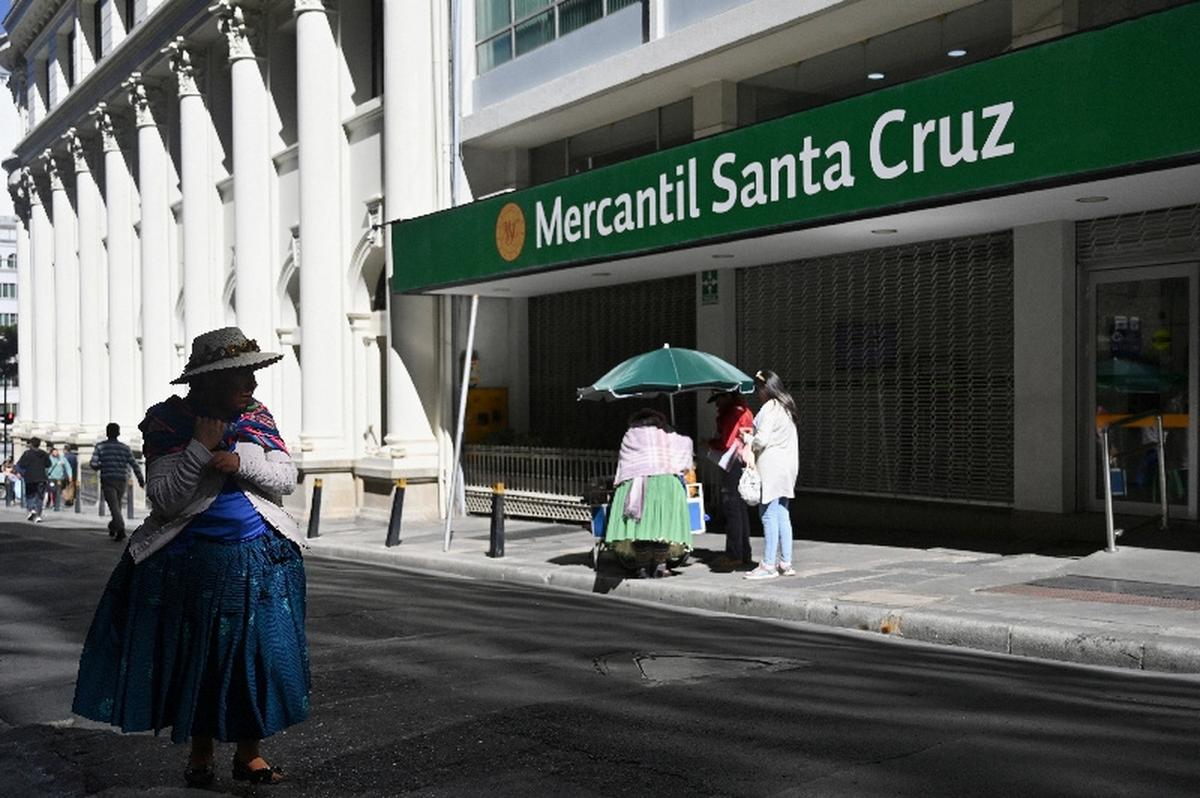 A woman walks past a closed branch of the Mercantil Santa Cruz bank, as several Bolivian banks temporarily closed branches due to ongoing unrest driven by anti-government demonstrations, in La Paz, Bolivia, May 19, 2026. REUTERS/Claudia Morales
