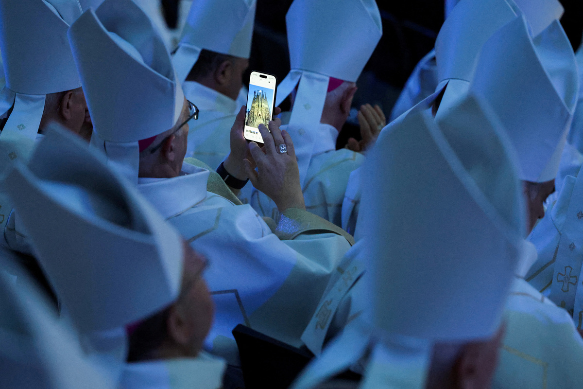 A member of the clergy looks at photographs of the Basilica of the Sagrada Familia on a smartphone on the day the inauguration and blessing of the Tower of Jesus Christ by Pope Leo XIV during his apostolic journey in Barcelona, Spain, June 10, 2026. REUTERS/Nacho Doce