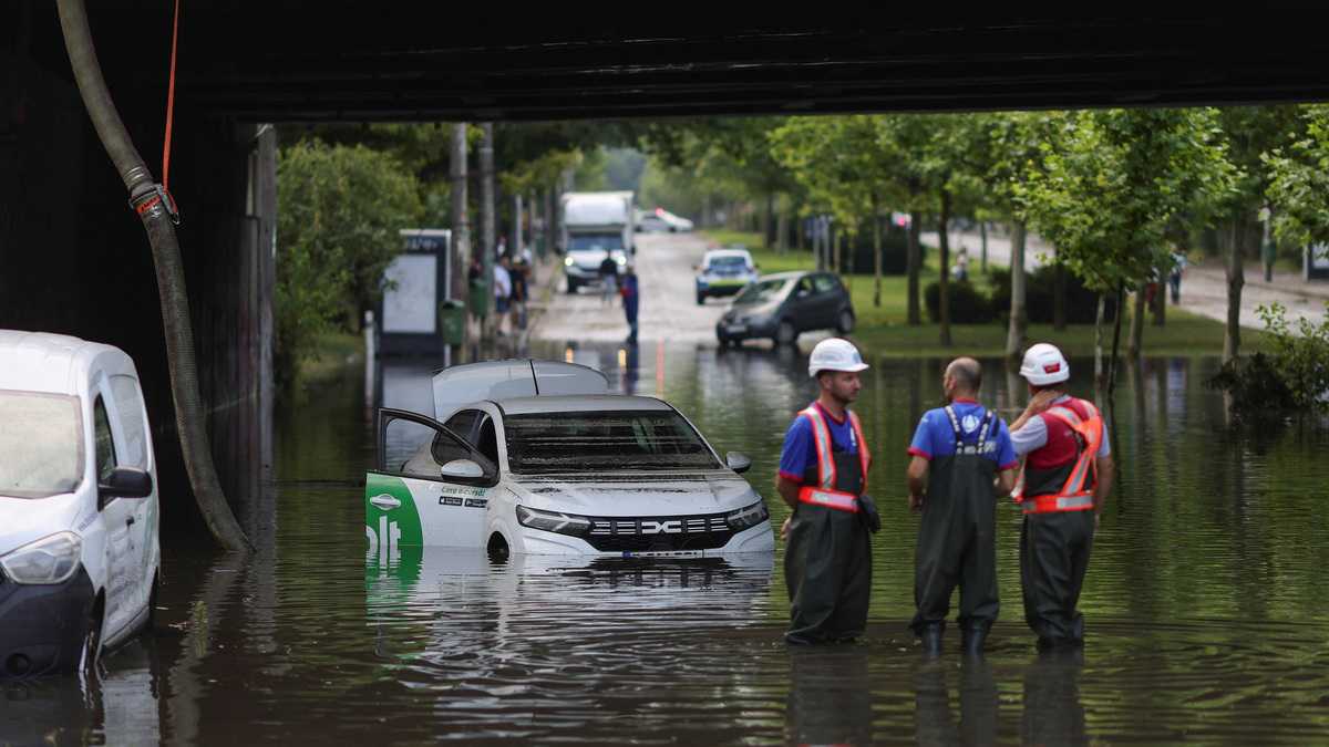 Workers watch as rainwater is pumped out of a flooded railway underpass in northern Bucharest, Romania, July 1, 2026. Inquam Photos/Octav Ganea via REUTERS