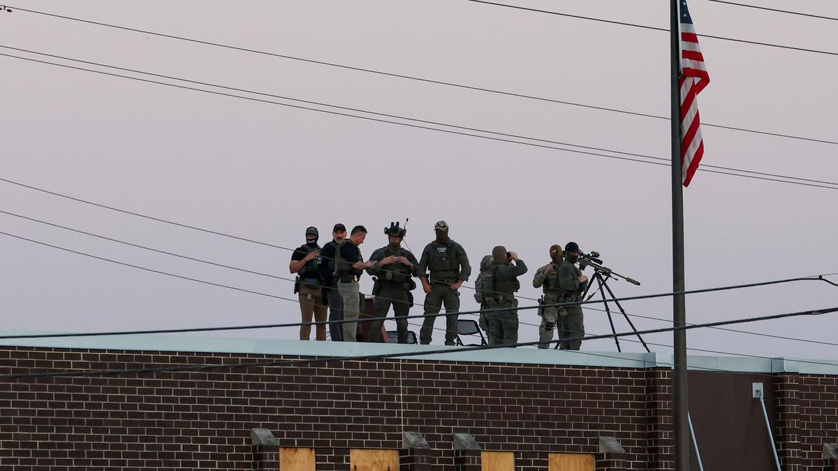 A group of federal agents stand on the roof of the U.S. Immigration and Customs Enforcement holding facility in Broadview, Illinois, on Oct. 3, 2025. (Stacey Wescott/Chicago Tribune/TNS)