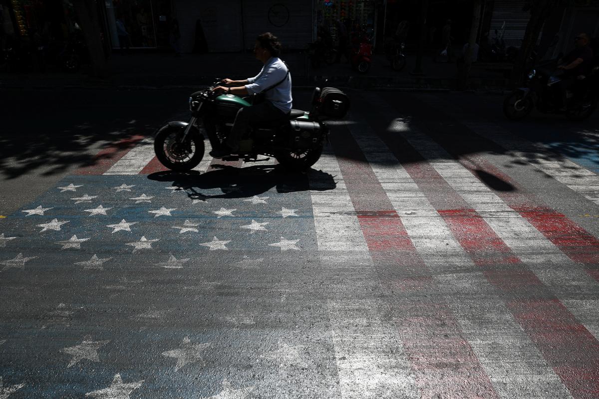 A person rides a motorcycle over a U.S. flag painted on a street, in Tehran, Iran, May 12, 2026. Majid Asgaripour/WANA (West Asia News Agency) via REUTERS ATTENTION EDITORS - THIS PICTURE WAS PROVIDED BY A THIRD PARTY