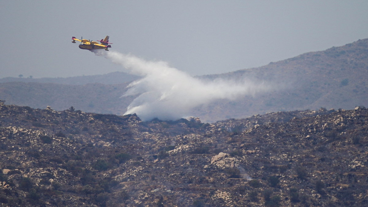 An aircraft drops water above wildfires affecting Almeria province, in Los Gallardos, Spain, July 11, 2026. 