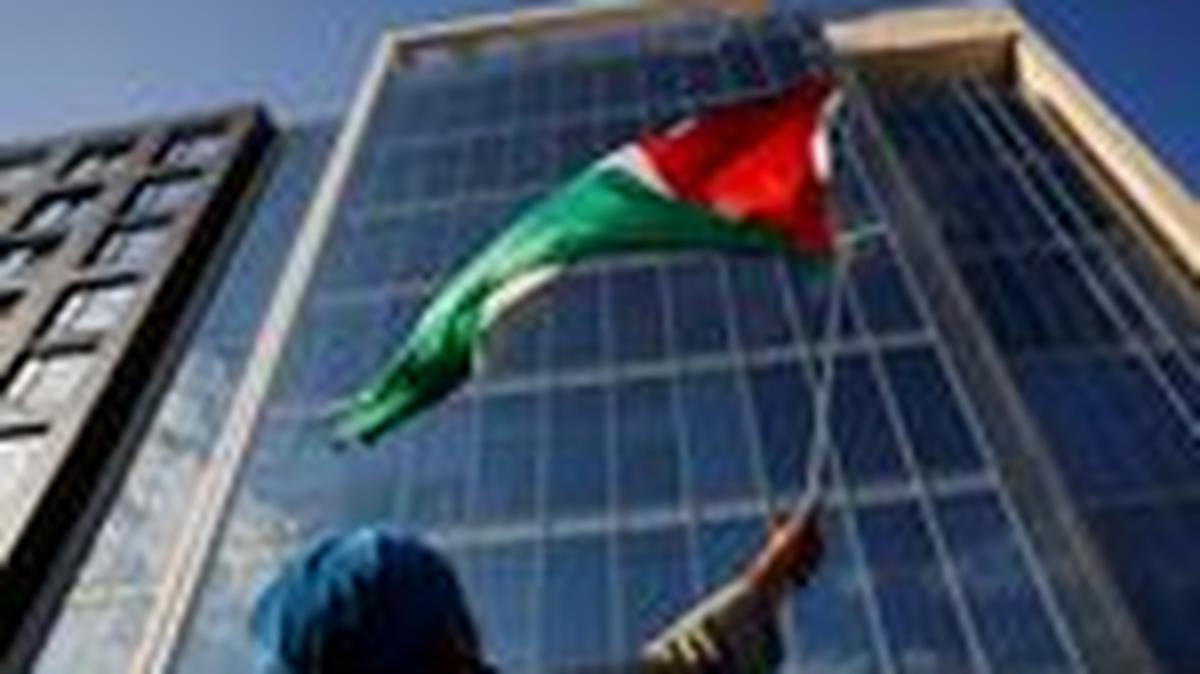 A demonstrator waves a Palestinian flag, during a protest against the U.S. backing of the Israeli military operation in Gaza, outside the Washington office of the American Israel Public Affairs Committee (AIPAC) in Washington, D.C., U.S., September 22, 2025. REUTERS/Daniel Becerril/ File Photo