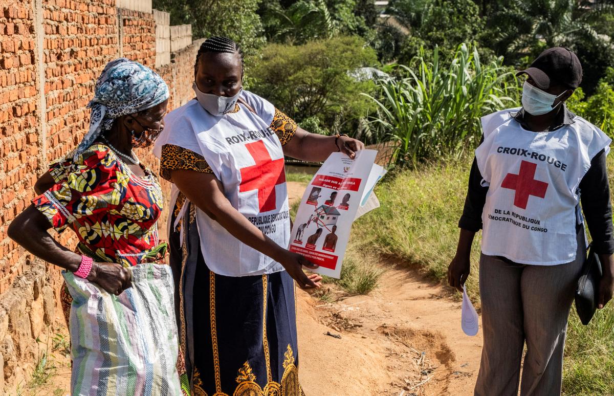 FILE PHOTO: Red Cross outreach workers talk to a woman in a residential area, to raise awareness about Ebola, as aid agencies intensify efforts to contain an Ebola outbreak caused by the Bundibugyo virus in Bunia, Democratic Republic of Congo, May 25, 2026. REUTERS/Stringer/File Photo