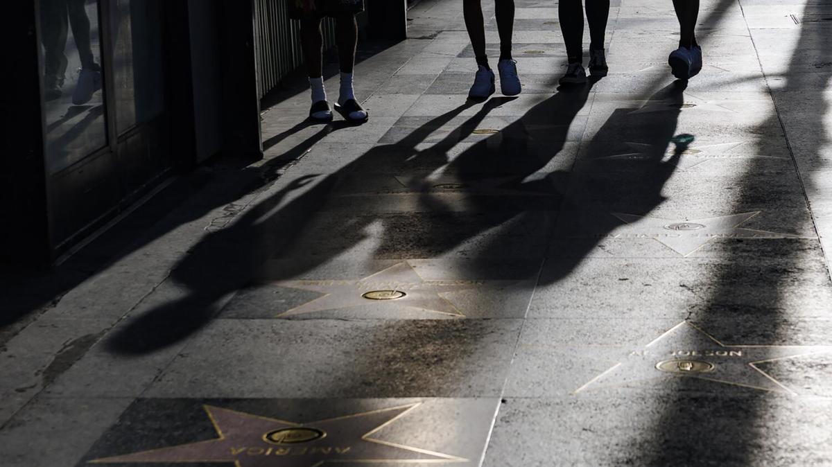 Tourists' long shadows are cast on the Walk of Fame along Hollywood Boulevard on April 23, 2026, in Hollywood. (Gina Ferazzi/Los Angeles Times/TNS)