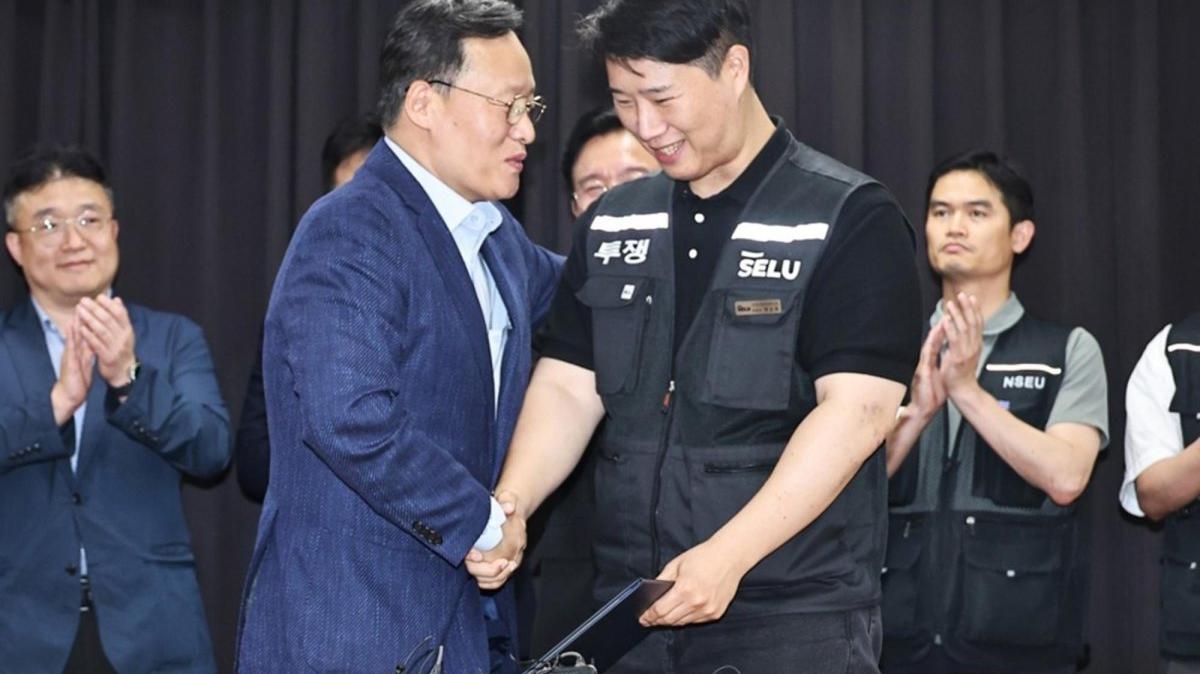 Yeo Myeong-gu (L), head of Samsung Electronics Co.'s device solutions division's people team, and Choi Seung-ho, head of Samsung's largest labor union, shake hands at the Gyeonggi District Employment and Labor Office in Suwon, south of Seoul, South Korea. Photo by YONHAP / EPA
