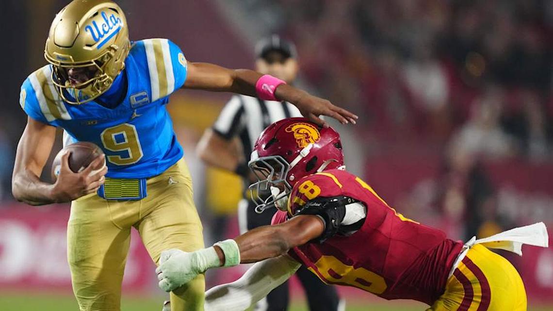  Nov 29, 2025; Los Angeles, California, USA; UCLA Bruins quarterback Nico Iamaleava (9) is tackled by Southern California Trojans linebacker Eric Gentry (18) in the second half at United Airlines Field at Los Angeles Memorial Coliseum. Mandatory Credit: Kirby Lee-Imagn Images | Kirby Lee-Imagn Images 