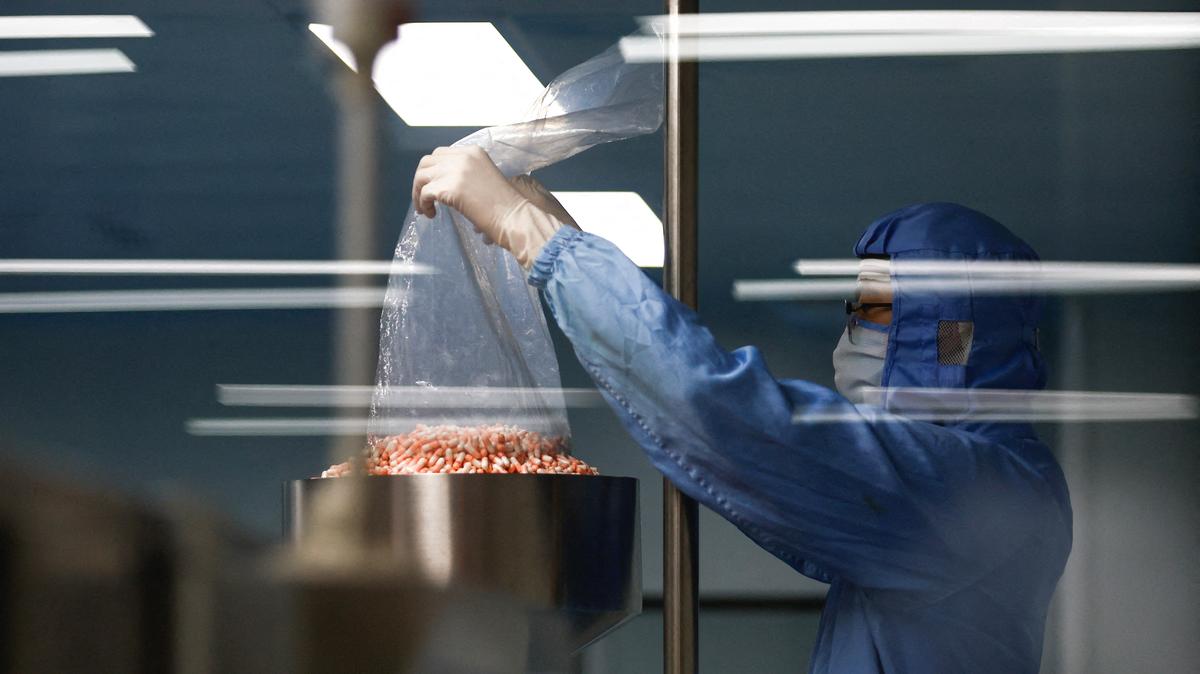An employee works on a production line manufacturing cold medicine at a workshop during an organised media tour at Youcare Pharmaceutical Group, in Beijing, China January 10, 2023. REUTERS/Tingshu Wang