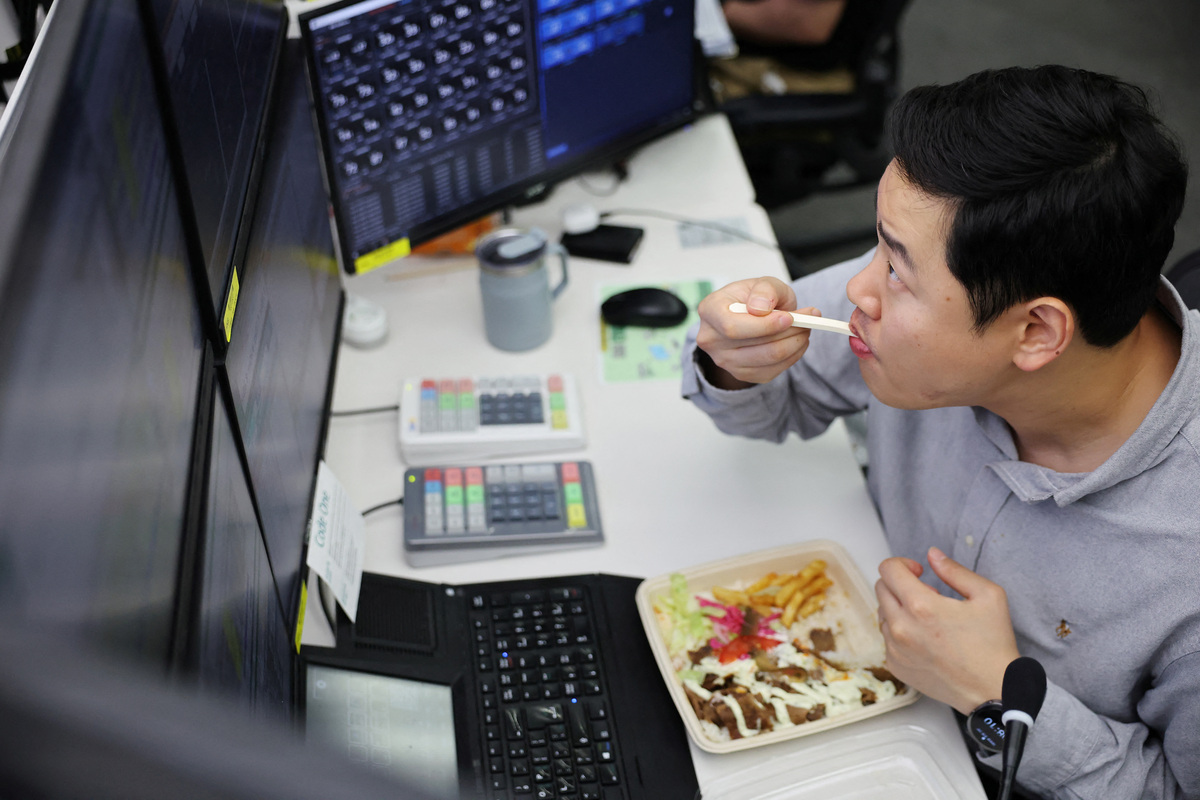 Lee Seok Jin, manager of Financial Markets Division and FX Platform Business Dept, eats dinner while working a late-night shift in preparation for the launch of South Korea's 24-hour won-dollar trading market from July 6, at Hana Bank's dealing room in Seoul, South Korea, June 16, 2026.    REUTERS/Kim Hong-Ji