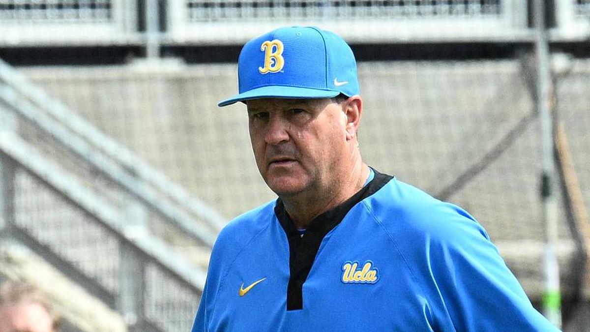  Jun 17, 2025; Omaha, Neb, USA; UCLA Bruins head coach John Savage (22) walks to the dugout before the restart of the game against the LSU Tigers at Charles Schwab Field. Mandatory Credit: Steven Branscombe-Imagn Images | Steven Branscombe-Imagn Images 