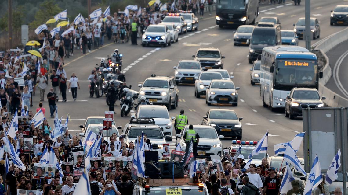 Relatives, friends and supporters of Israeli hostages held in the Gaza Strip since the October 7 attack by Hamas militants in southern Israel, hold the Israeli flag, placards and images of those taken during a protest calling for their release as they march towards Jerusalem on Nov. 17, 2023, amid the ongoing battles between Israel and the Palestinian group Hamas. (Ahmad Gharabli/AFP/Getty Images/TNS)