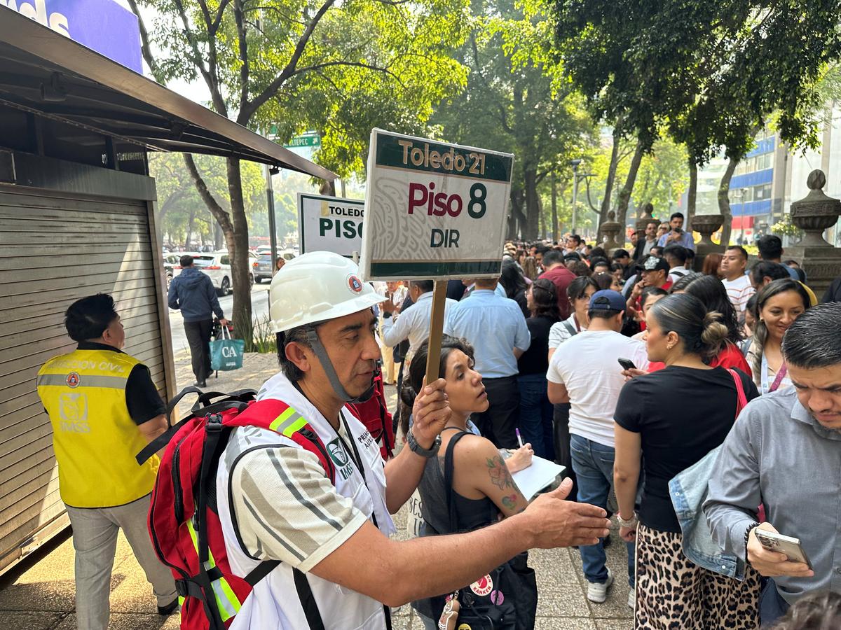 People wait outside their homes and buildings after an alarm sounded warning of a tremor, in Mexico City, Mexico, May 4 ,2026. REUTERS/Henry Romero