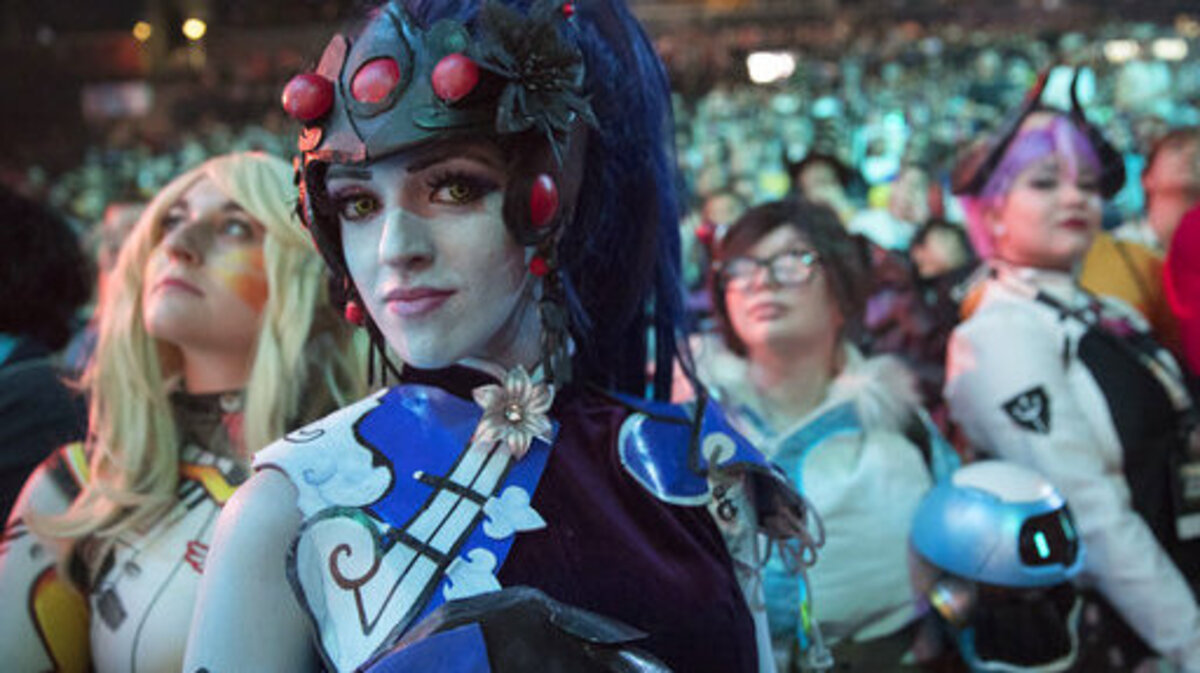FILE - In this July 28, 2018 file photo, cosplayer fans watch the competition between Philadelphia Fusion and London Spitfire during the Overwatch League Grand Finals competition, at Barclays Center in the Brooklyn borough of New York. Most professional esports are devoid of female players at their highest levels, even though 45 percent of U.S. gamers are women or girls. Executives for titles like League of Legends and Overwatch say they are eager to add women to pro rosters, but many female gamers say they’re discouraged from chasing such careers by toxic behavior and other barriers.