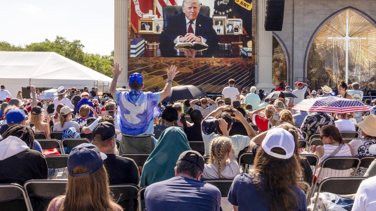 Attendees watch a pre-recorded video of President Donald Trump at Rededicate 250: A National Jubilee of Prayer, Praise & Thanksgiving in Washington on Sunday. Thousands of people gathered on the National Mall for a daylong rally blending Christian prayer and political fervor.