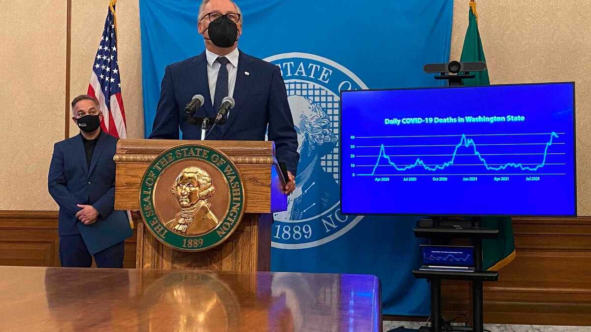 Washington Gov. Jay Inslee, front, talks to reporters in Olympia, Wash., Thursday, Oct. 14, 2021, as Secretary of Health Umair Shah looks on. Inslee announced that starting Nov. 15, people in the state will need to either provide proof of COVID-19 vaccination or a negative test in order to attend large events. (AP Photo/ Rachel La Corte)